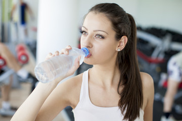 Girl drinking water in the gym