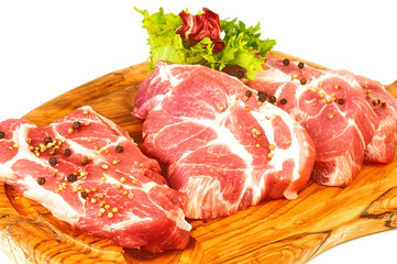 Свежее мясо на доске с зеленью и перцем