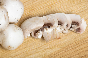 Three white button mushrooms and slices