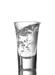 Vodka poured into a glass isolated on white