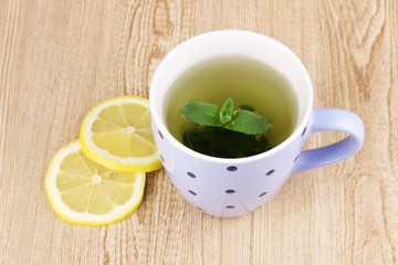 Mint tea with mint leaf and lemon on wooden background