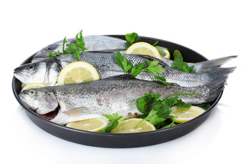 Fresh fishes with lemon and parsley on plate isolated on white