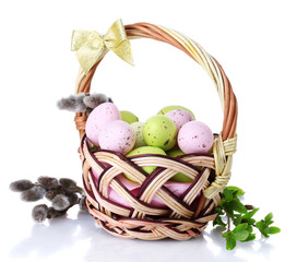 basket with Easter eggs and pussy-willow twigs isolated on white