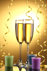 glasses of champagne, candles  and streamer on yellow