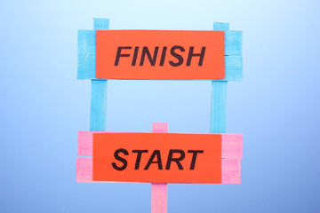 Start, finish wooden boards on blue background