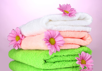 Obraz na płótnie Canvas towels and beautiful flowers on pink background