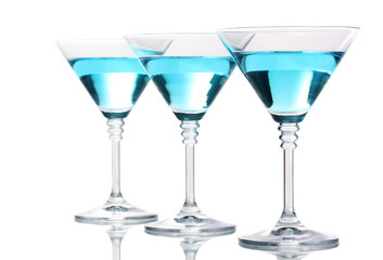 Blue cocktail in martini glasses isolated on white