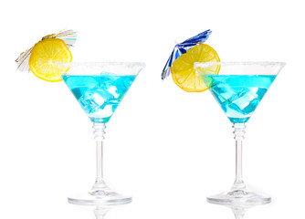 Blue cocktail in martini glasses isolated on white