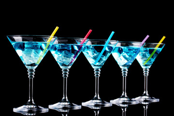 Blue cocktail in martini glasses isolated on black