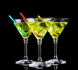 Yellow cocktail in martini glasses isolated on black