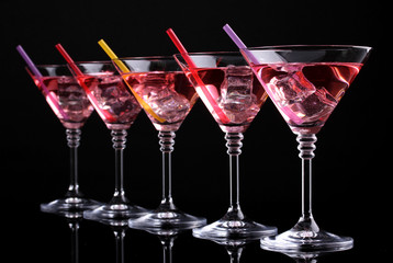 Red cocktail in martini glasses isolated on black