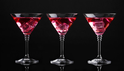 Red cocktail in martini glasses isolated on black