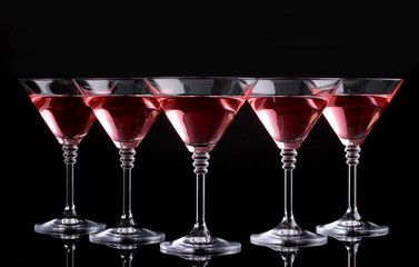 Red cocktail in martini glasses isolated on black