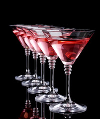 Red cocktail in martini glasses isolated on black
