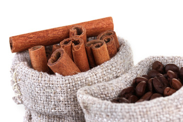 Coffee beans and cinnamon in canvas sacks close-up