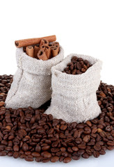 Coffee beans and cinnamon in canvas sacks isolated on white