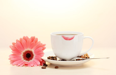 cup of coffee with lipstick mark and gerbera beans, cinnamon