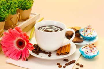 cup of coffee and gerbera  beans, cinnamon sticks