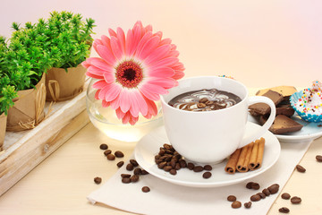 cup of coffee and gerbera  beans, cinnamon sticks