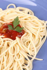 Italian spagetti cooked with tomato sauce in a blue plate