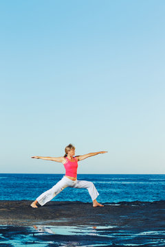 Beautiful Yoga woman Practicing Yoga by the Ocean