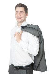Happy young businessman stands with his jacket over his shoulder