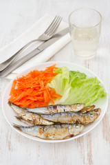fried sardines with lettuce and carrot on the plate