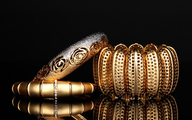 Beautiful golden bracelets isolated on black background