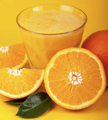 Orange juice and slices of orange isolated on yellow