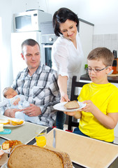 Mutter bedient Familie am Esstisch