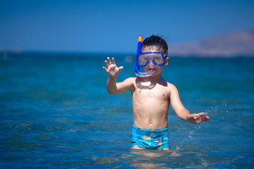 A boy in a sea with a swimming mask and snorkel