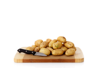 Fresh vegetables, potatoes, wooden chopping board.