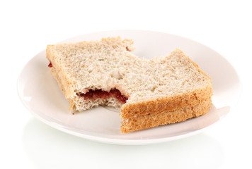 Fototapeta na wymiar Bitten sandwich with jam on plate isolated on white