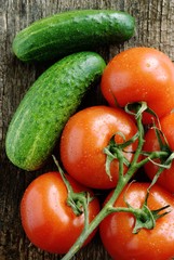 group of cucumbers and tomatoes on the old board