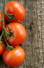 Red tomatoes on the old board