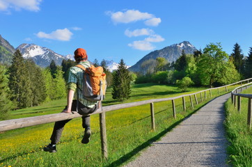 Wanderer sitzt auf Zaunstange