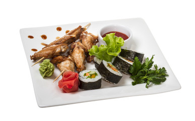 Buffalo chicken wings on plate with sushi