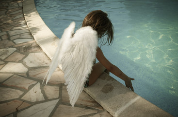 petit ange posé au bord de la piscine
