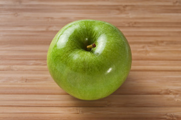 Grüner Apfel auf Holzbrett