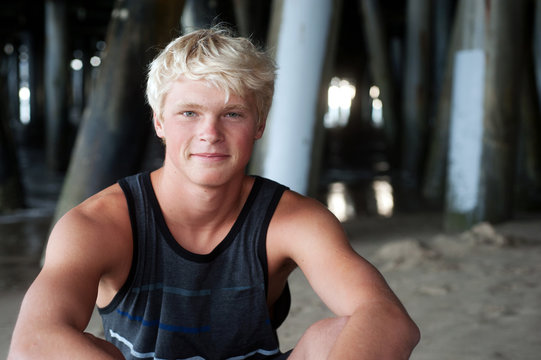 portrait of a teenage surfer boy at the beach