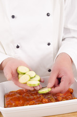female chef with zucchini cut into slices