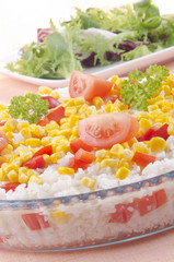 rice in a glass bowl with diced peppers, sweet corn