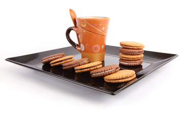 Cup of tea with biscuits on black Dish, breakfast