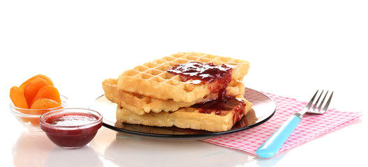 Tasty waffles with jam on plate isolated on white