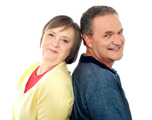 Portrait of senior couple back to back in studio