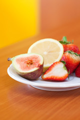 lemon, fig and strawberries on a plate