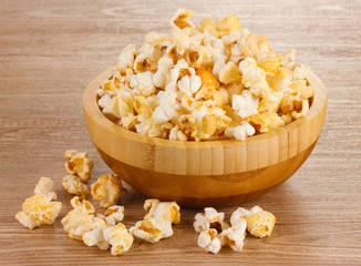 popcorn in wooden bowl on wooden table