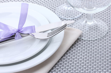 White empty plates, fork and knife tied with a ribbon and