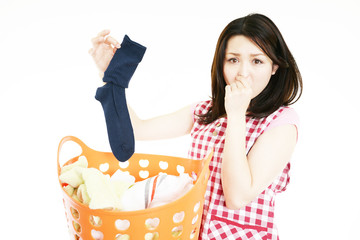 靴下を持ち鼻をつまむ女性