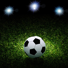 Fototapeta premium Soccer ball on grass against black background